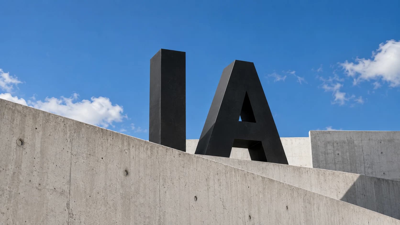 Letras IA em uma construção de concreto sob o céu azul